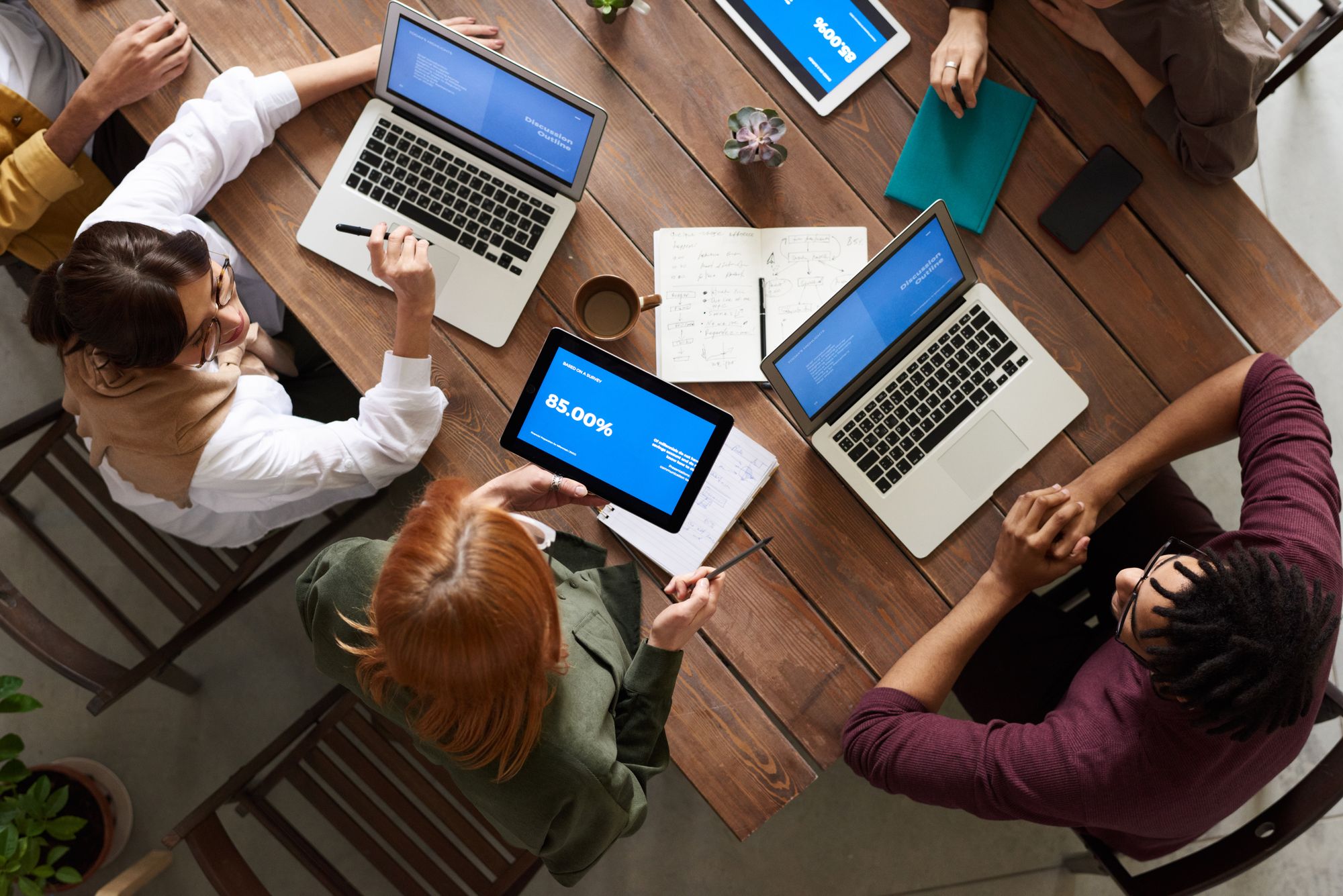 Séance de travail : ordinateurs portables, croquis d'interface et notes sur une table