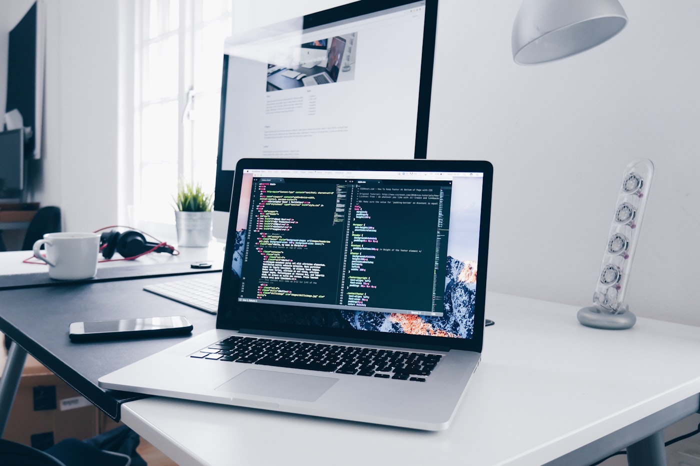 Poste de travail design et développement : écran de code, maquette et outils
